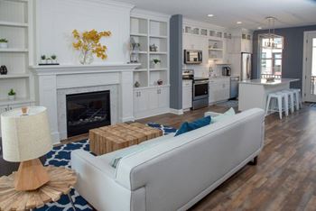 A white couch sits in a living room with a fireplace and a lamp.